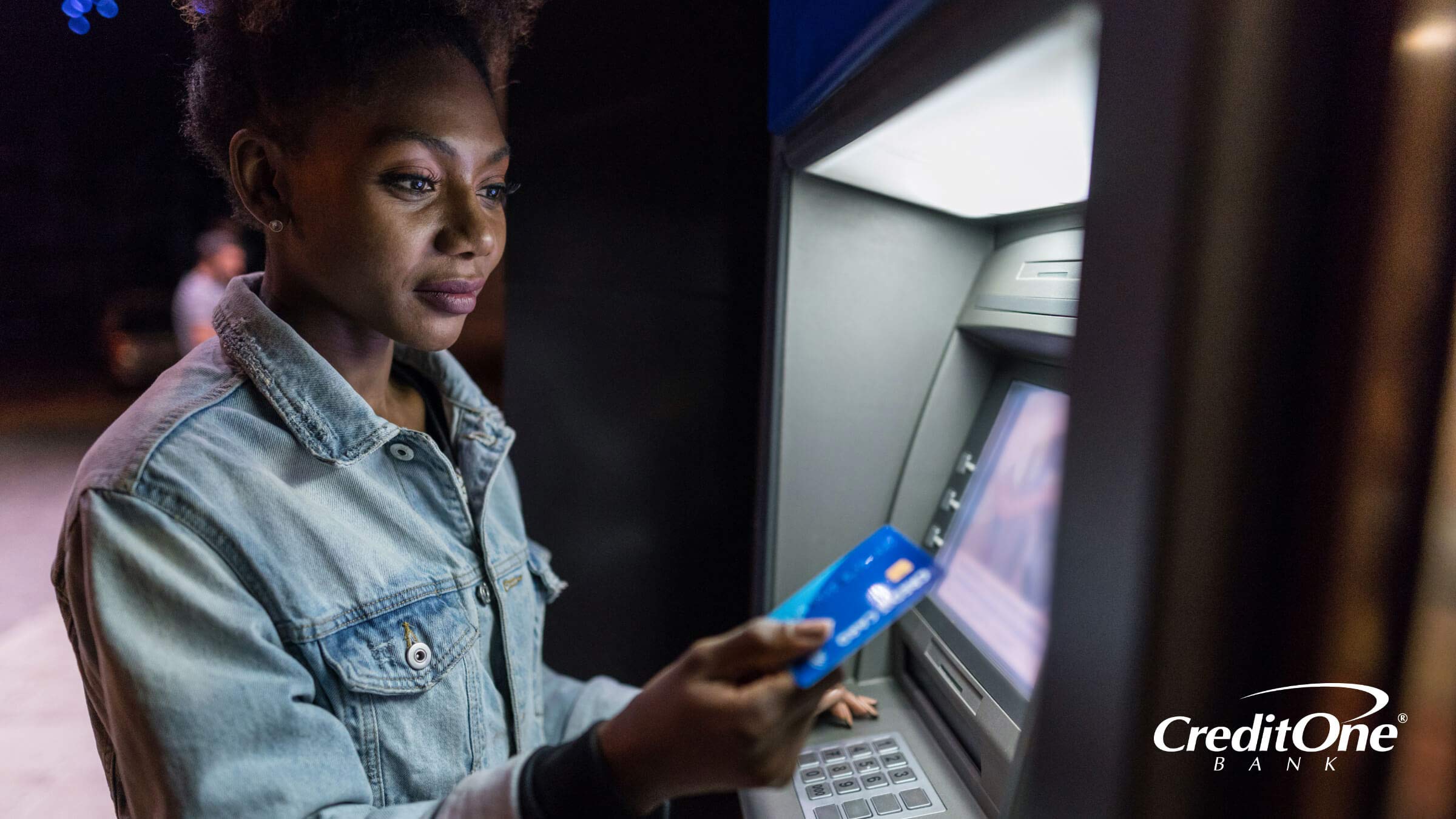 Closeup of a woman using her credit card at an ATM machine